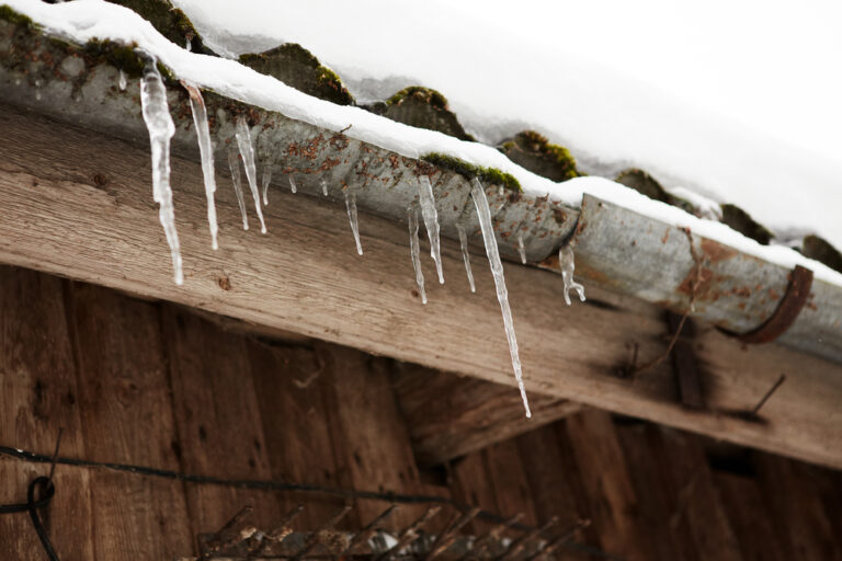 Ice dams forming at the edge of a roof and gutter line